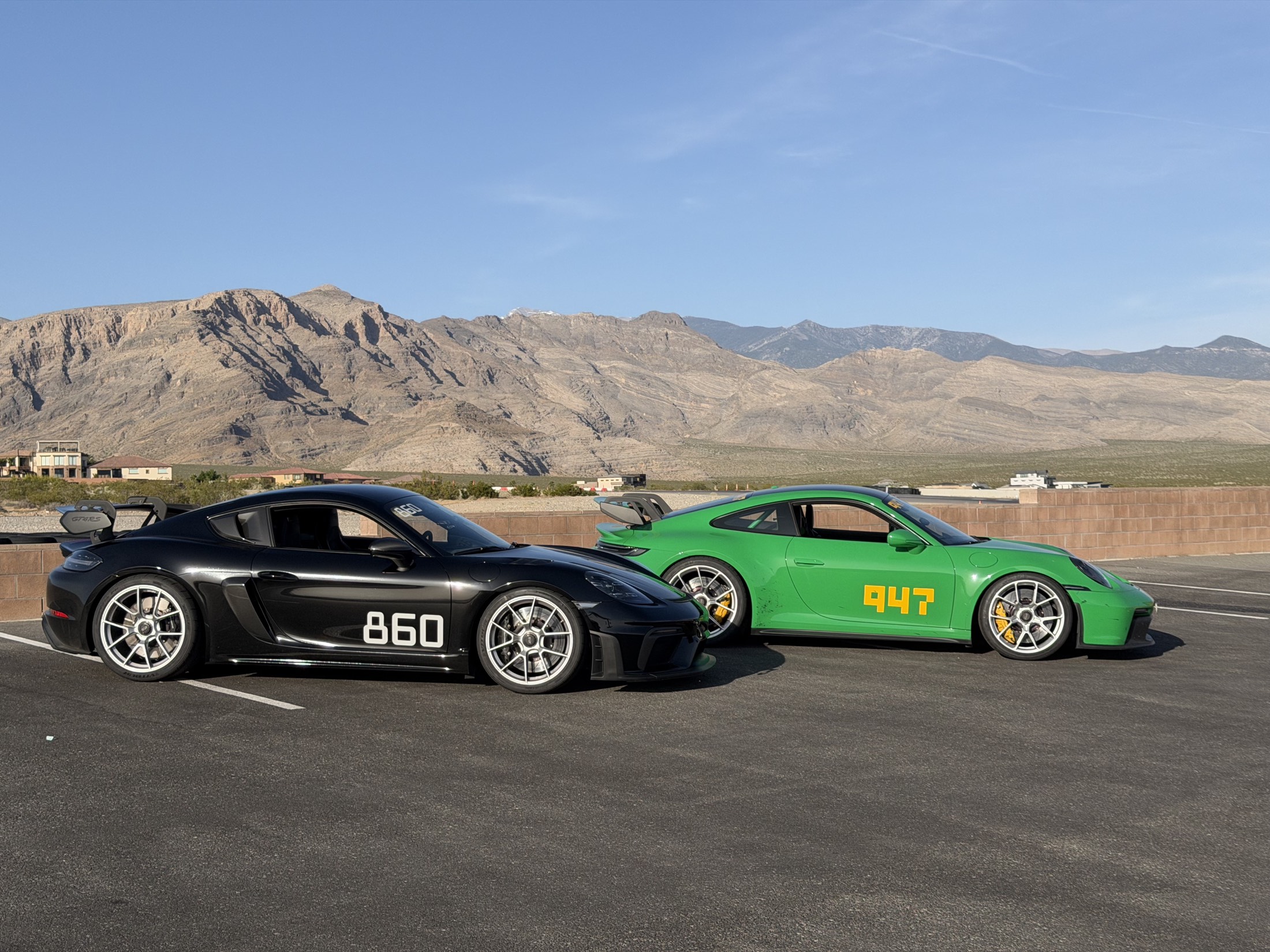 LTB Racing founders' own cars — a black Porsche Cayman and a python green 911